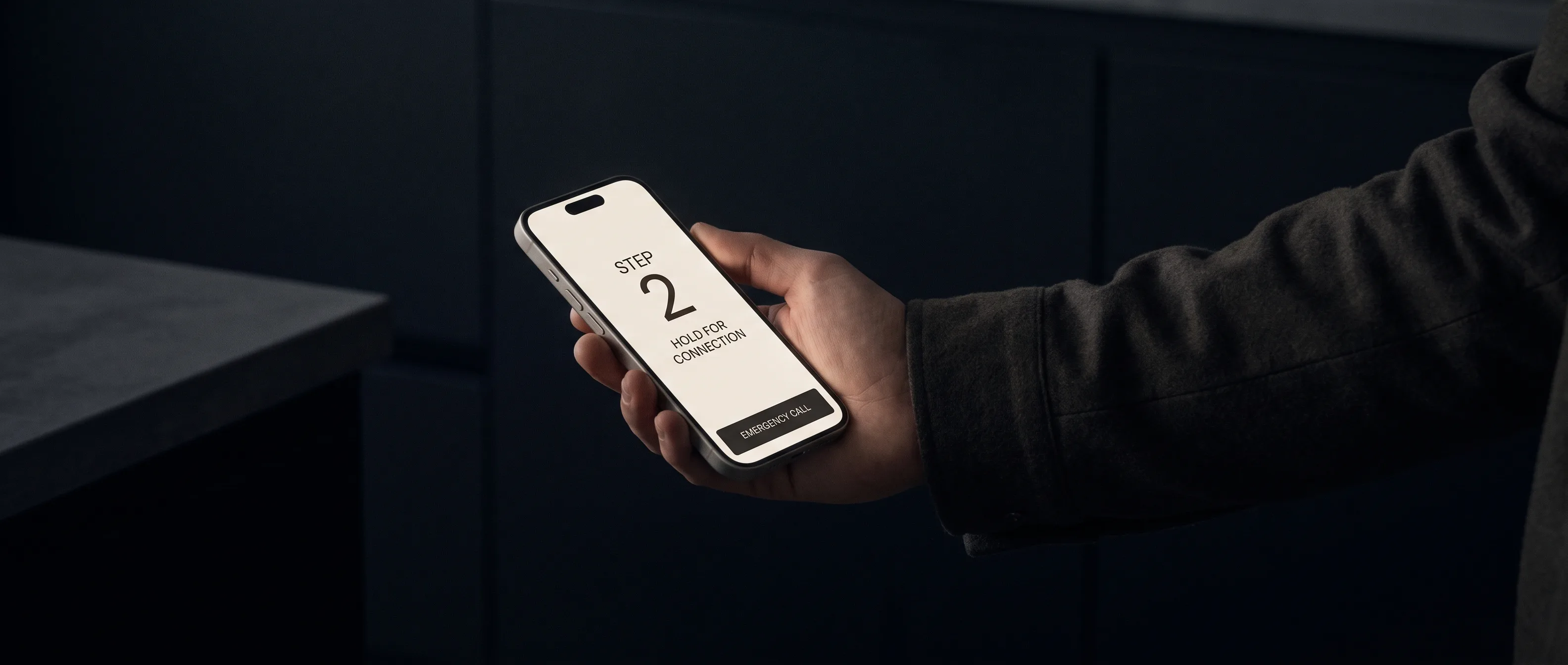 A phone held at arm's length in poor light shows one large-type first-aid instruction with a persistent emergency-call button.
